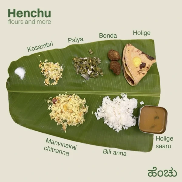 Ugadi Habbada Oota meal on a banana leaf with kosambri, beans palya, bonda, holige, chitranna, rice and holige saaru